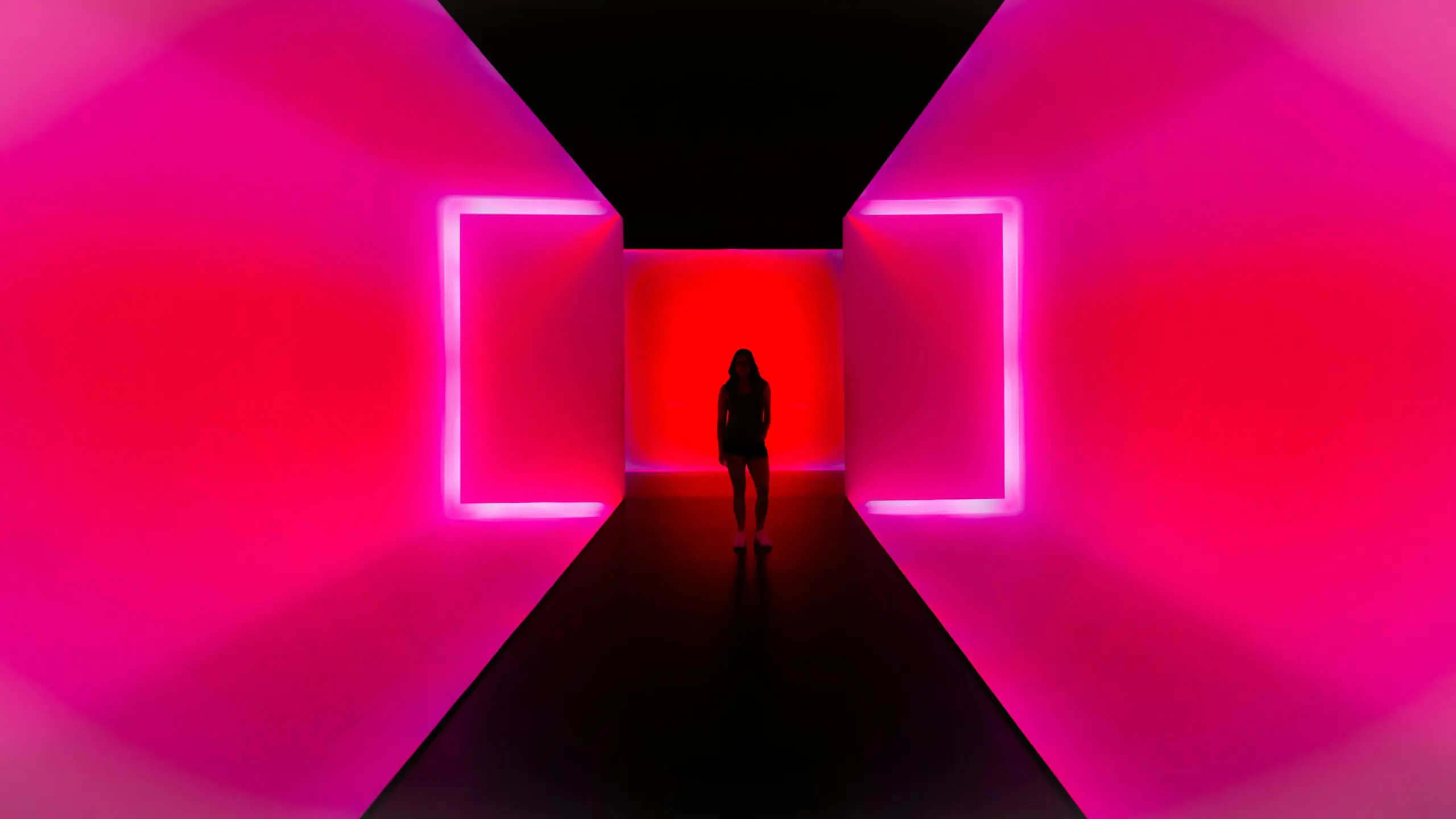 Salle d'exposition immersive où des images animées couvrent les murs et le sol