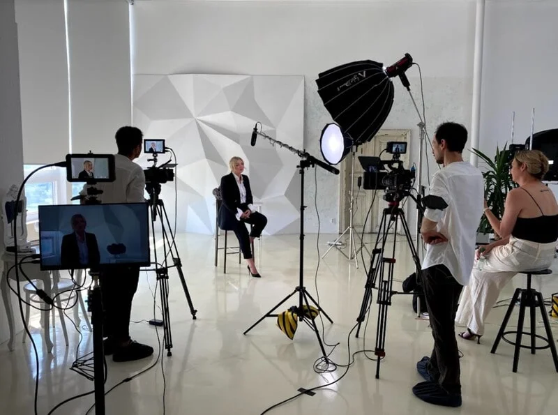 Plateau de tournage avec plusieurs caméras, lumières et une équipe de production