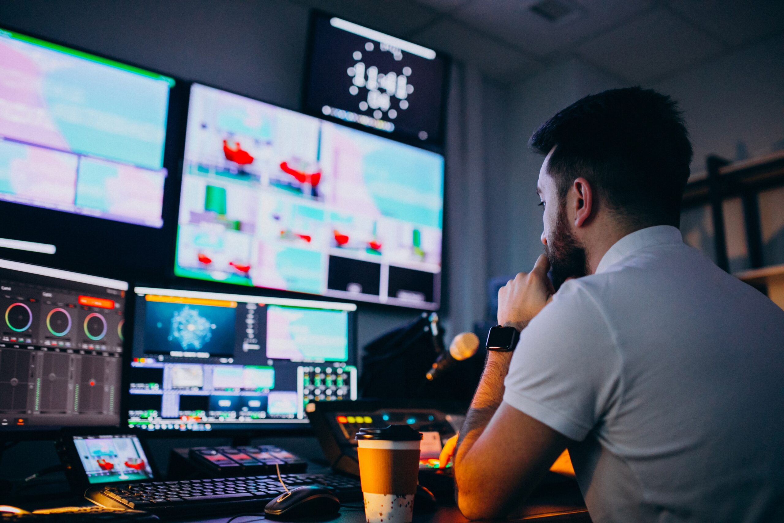 Monteur travaillant devant plusieurs écrans de post-production vidéo