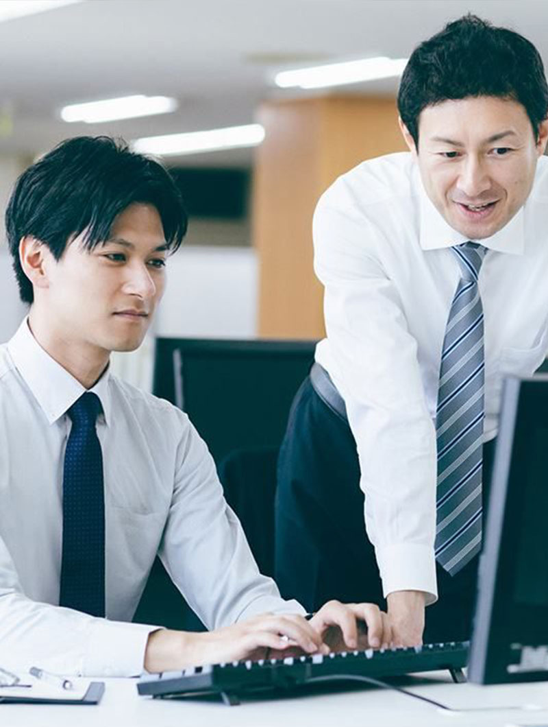 Deux collègues japonais examinant des données devant un ordinateur