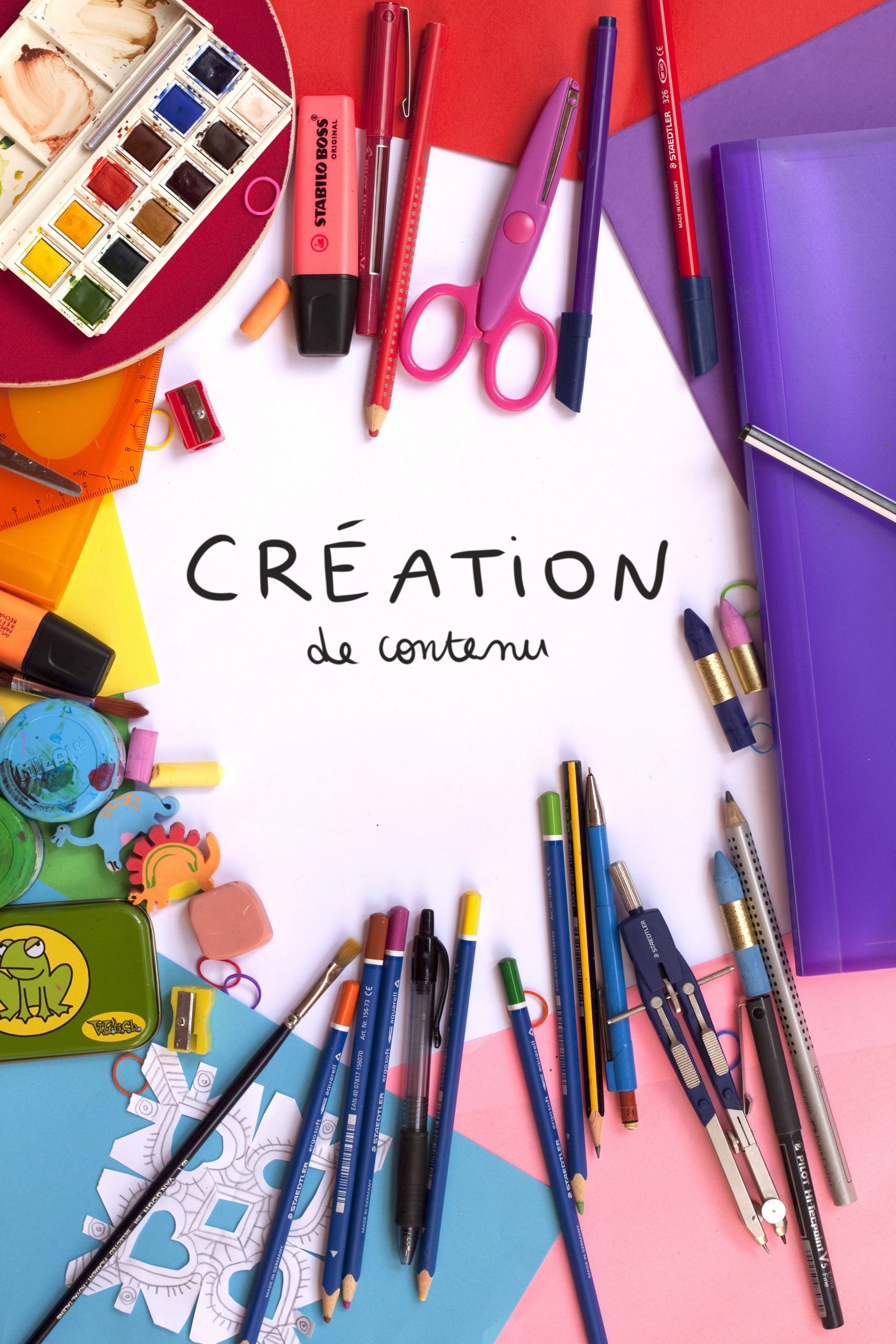 Papeterie et crayons de couleur sur une table de travail avec la mention création de contenu